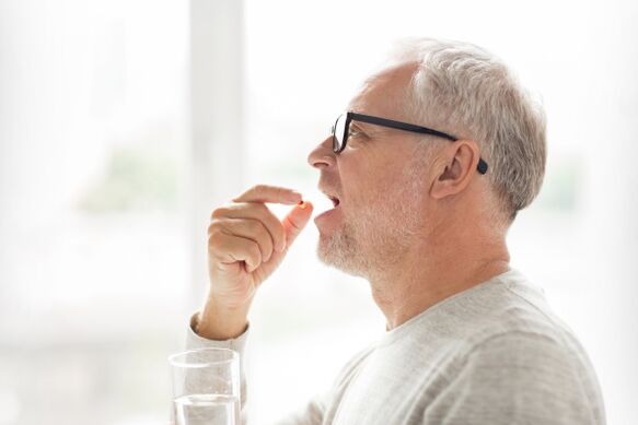 Un home toma un antibiótico para a prostatite